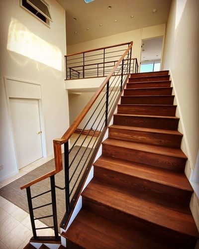 A wooden staircase with a metal railing in a house.