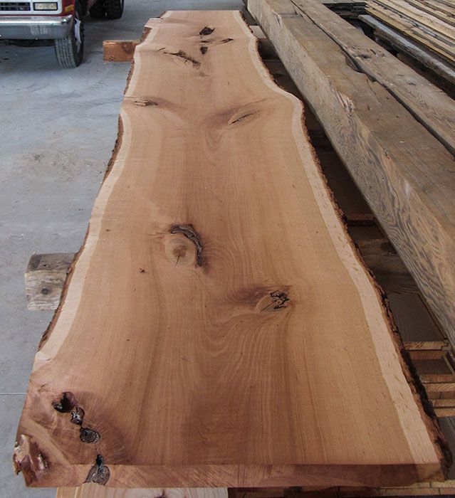 A large piece of wood is sitting on a pallet next to a truck.