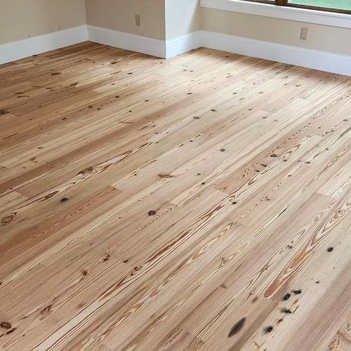 A room with a wooden floor and a window.