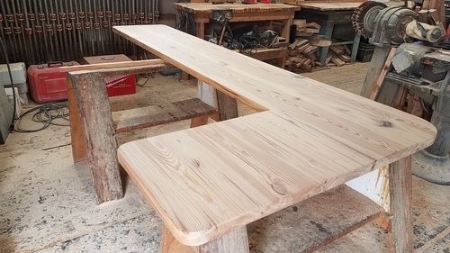 A wooden table is sitting on top of a wooden bench in a workshop.