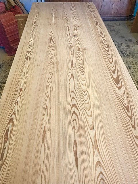 A wooden table is sitting on a concrete floor in a room.