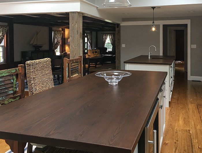 A kitchen with a large wooden table and wicker chairs