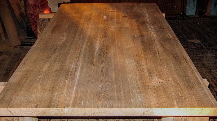 A wooden table is sitting on a wooden floor in a room.