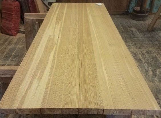 A wooden table is sitting on a wooden floor in a room.