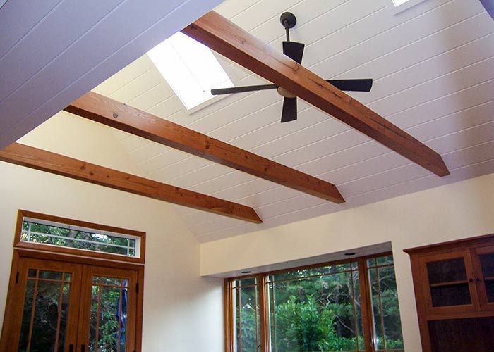 A living room with wooden beams and a ceiling fan