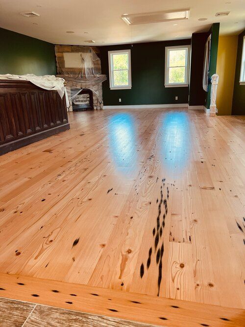 A large room with a wooden floor and a fireplace.