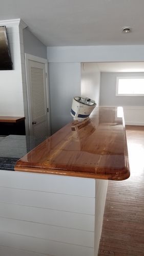 A wooden counter top in a kitchen with a bucket on top of it.