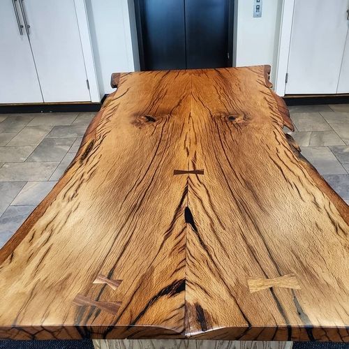 A large wooden table is sitting in front of an elevator.