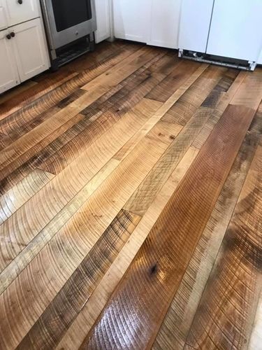 A kitchen with a wooden floor and white cabinets.