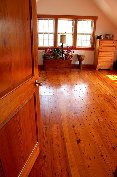 A bedroom with hardwood floors and a dresser.