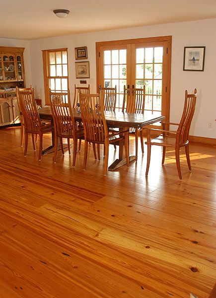 A dining room with a wooden table and chairs