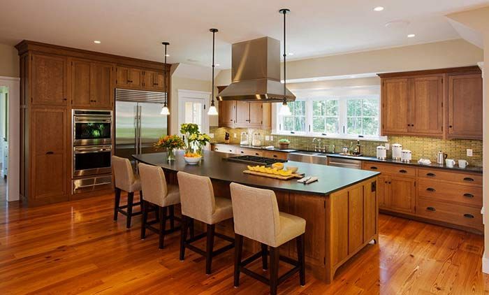 A kitchen with wooden cabinets , stainless steel appliances , and a large island.