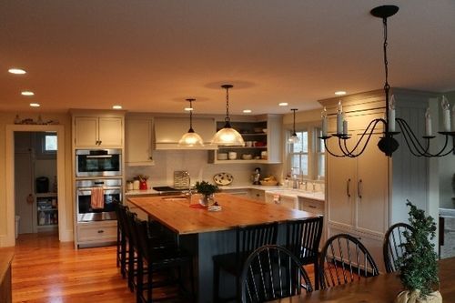 A kitchen with a large island and a chandelier hanging from the ceiling