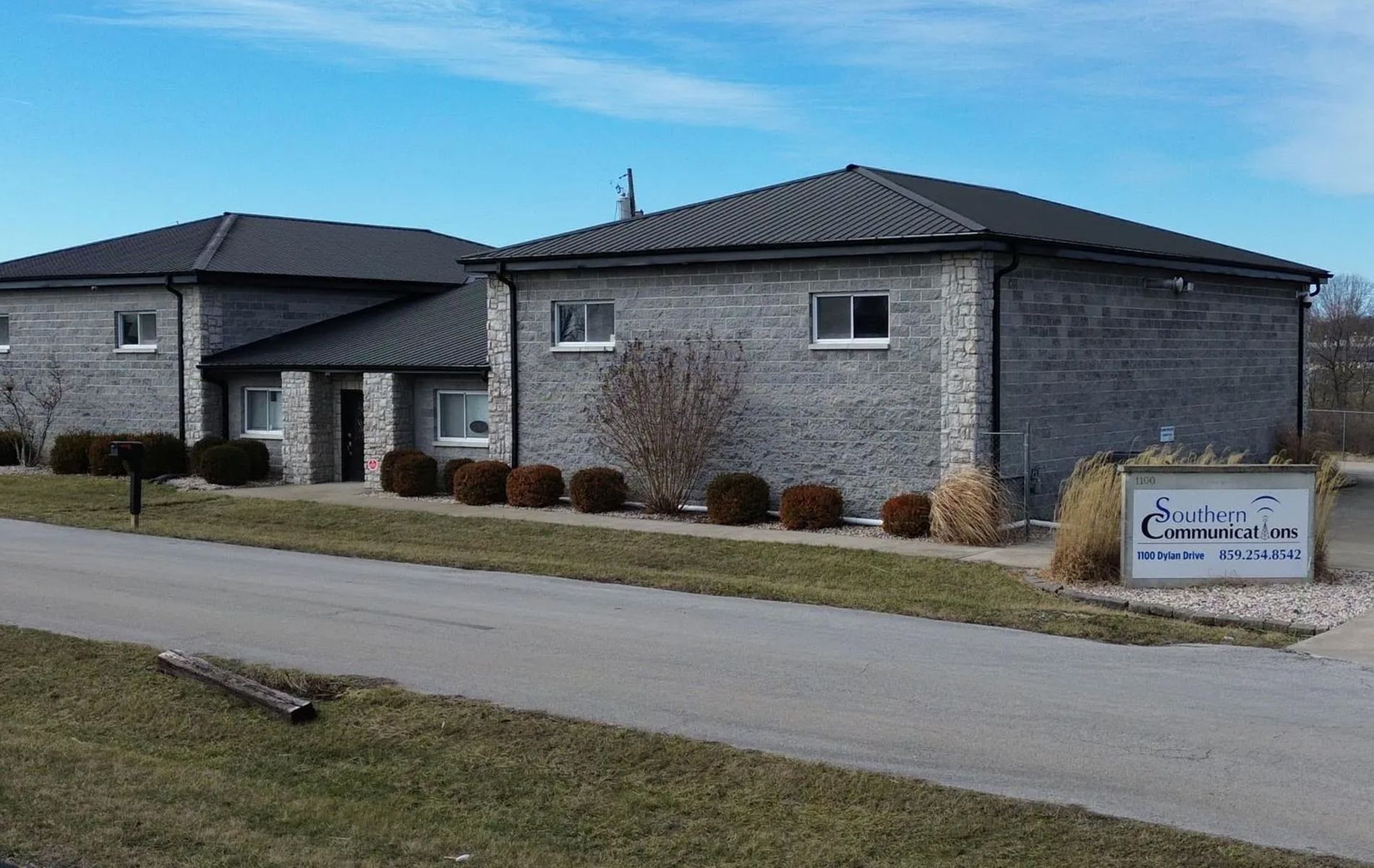 Gray brick building with a dark roof and a small sign that says "Sunset Hills."
