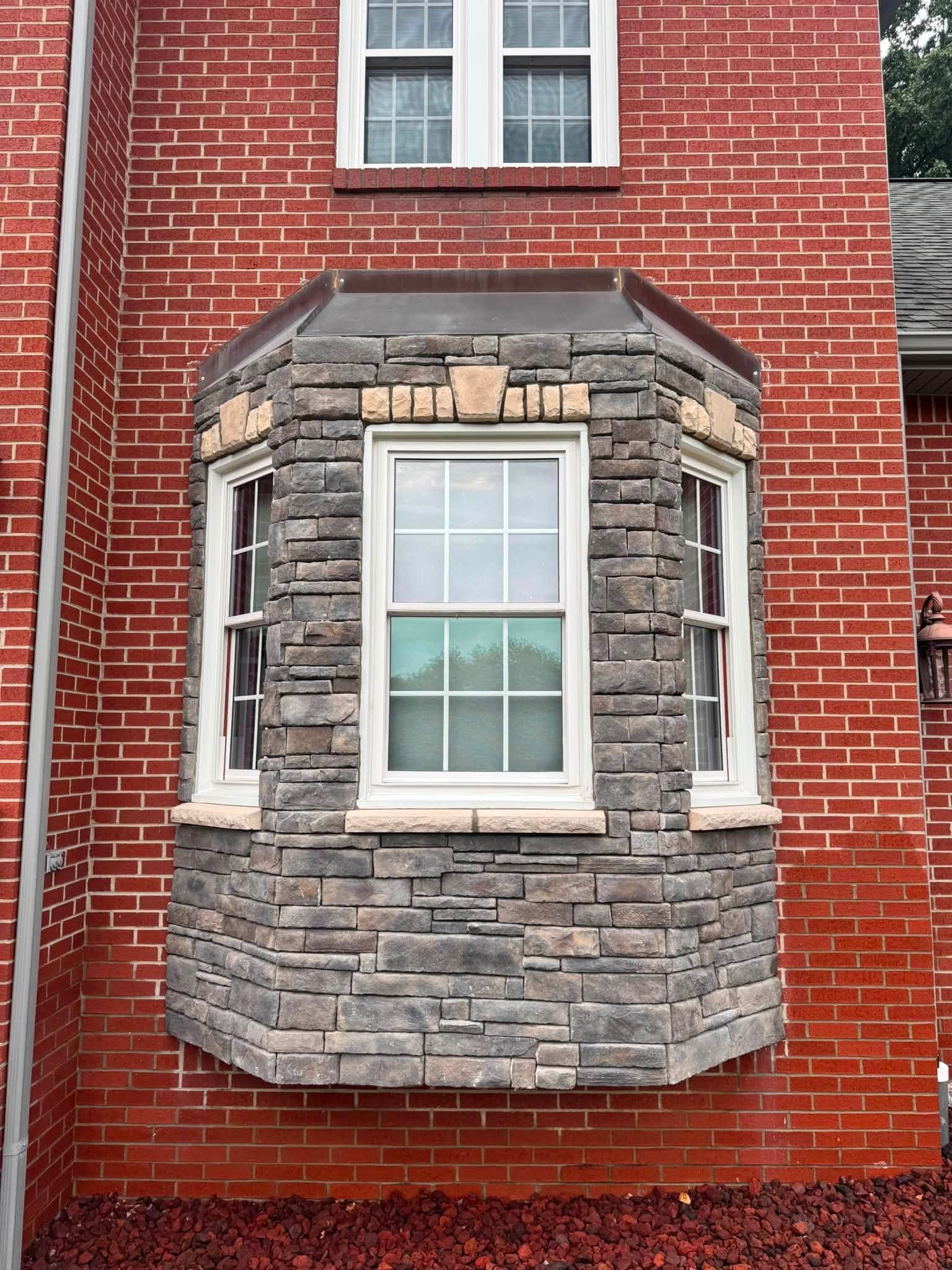 Stone bay window on a red brick building facade