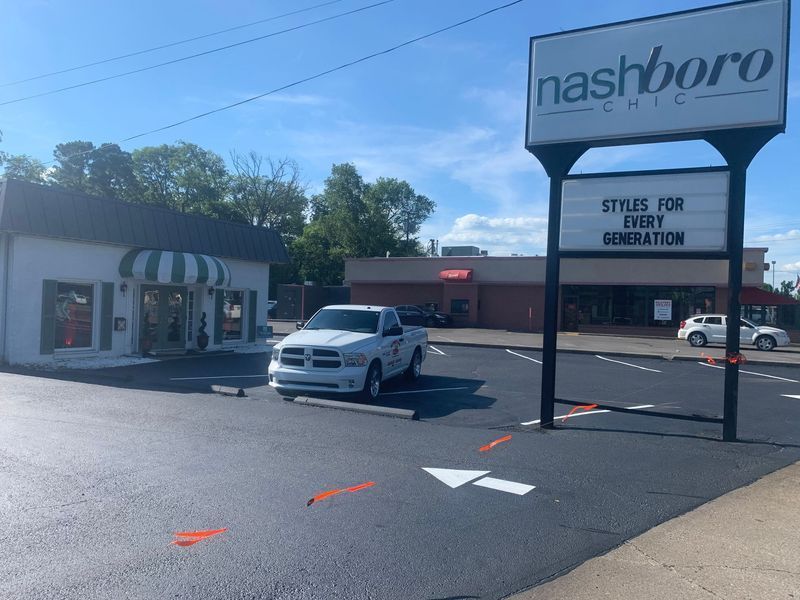 White pickup truck parked outside a clothing store, 