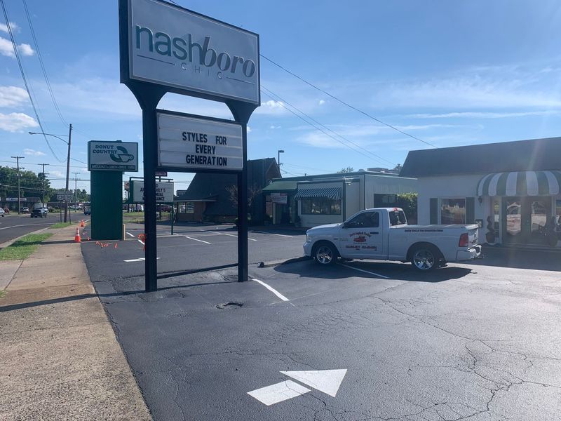 A parking lot with a truck, a sign for a business (nashborn), and an arrow indicating the direction of travel.