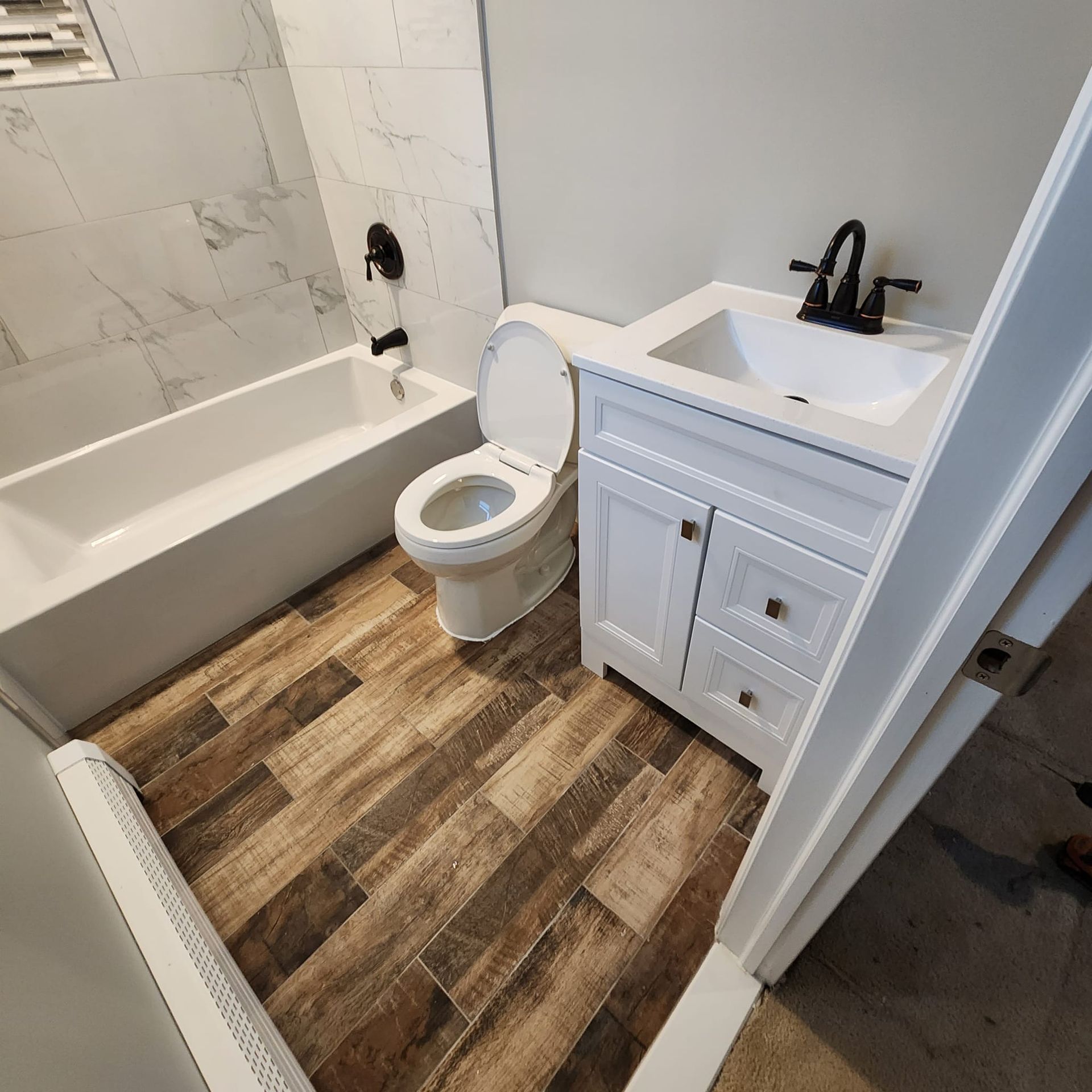 A bathroom with a toilet, sink and bathtub