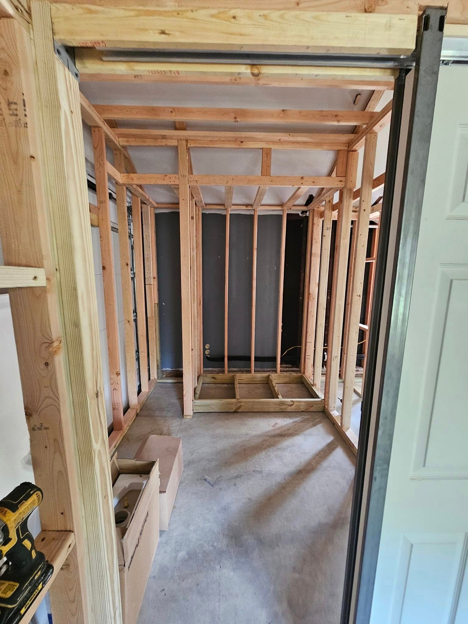 A room under construction with wooden beams and a door.