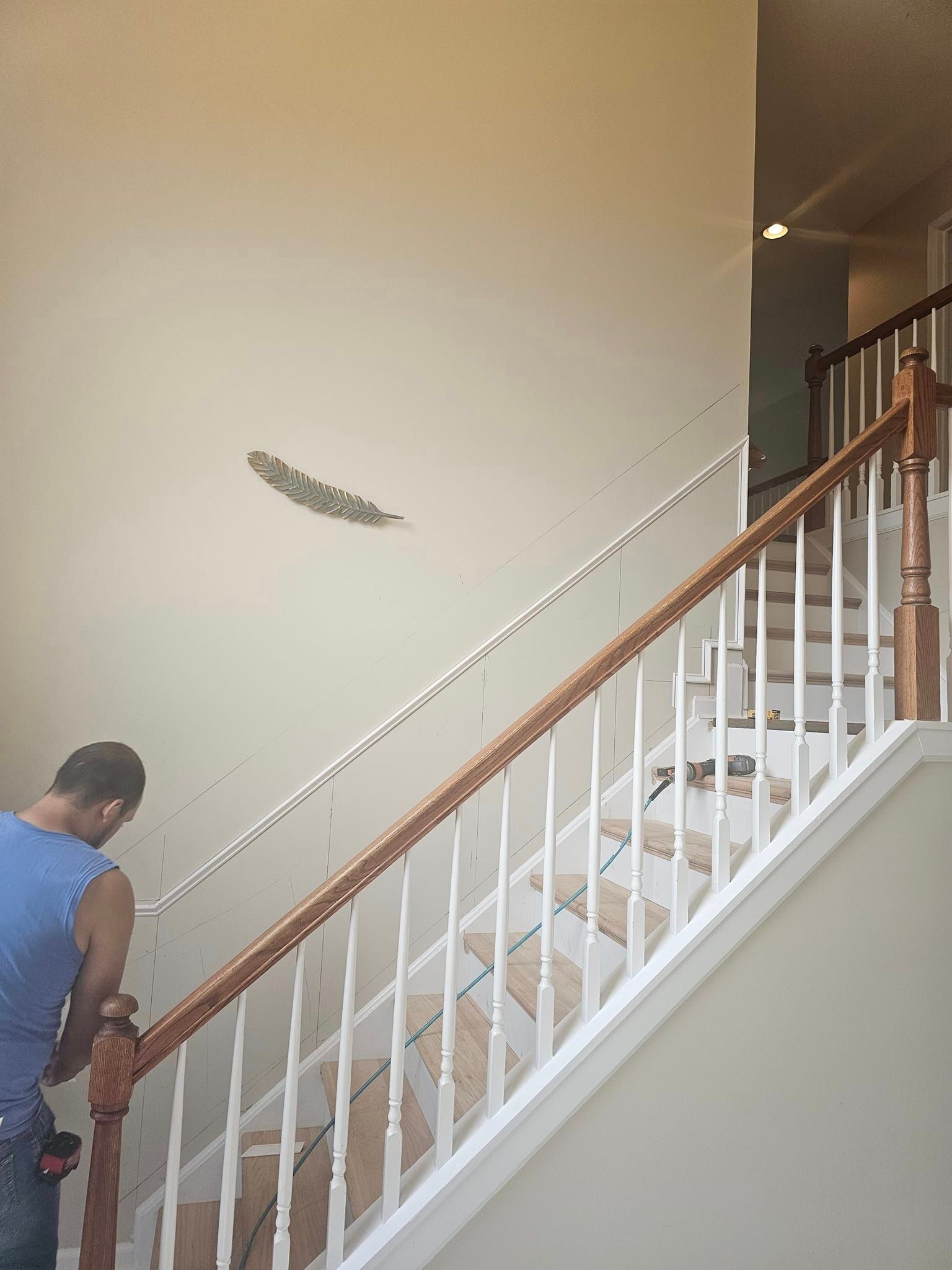 A man is working on a staircase in a house.