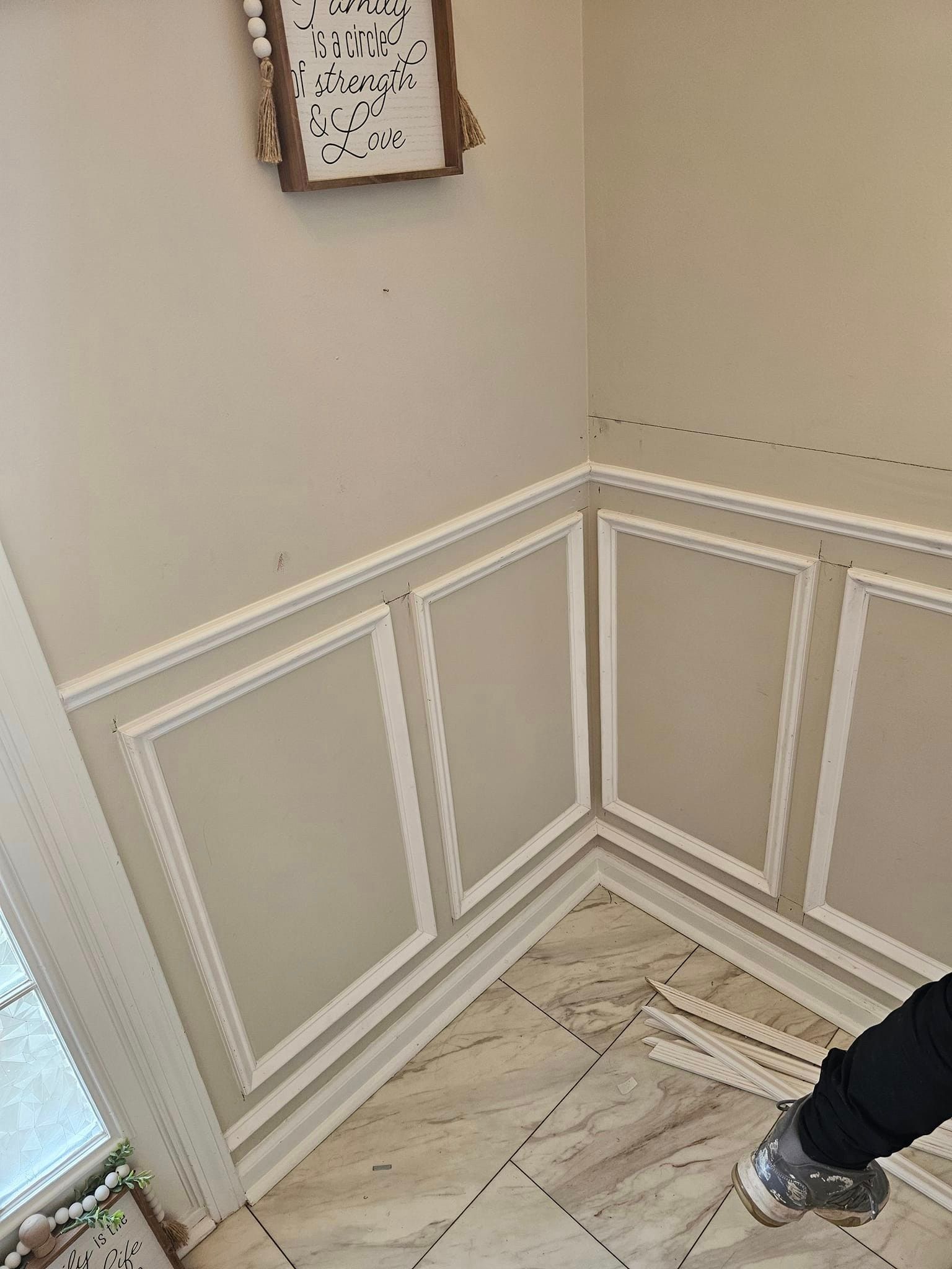 A person is standing in a room with a picture on the wall.