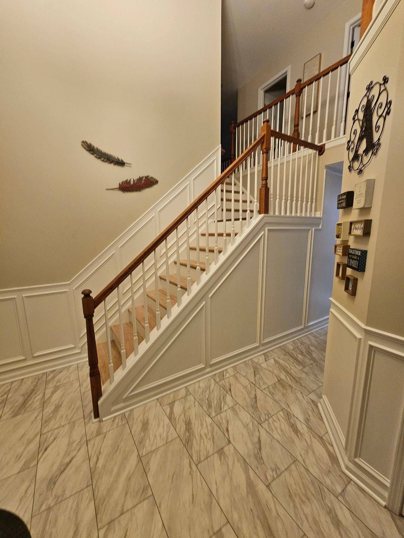 A hallway with stairs and a clock on the wall.