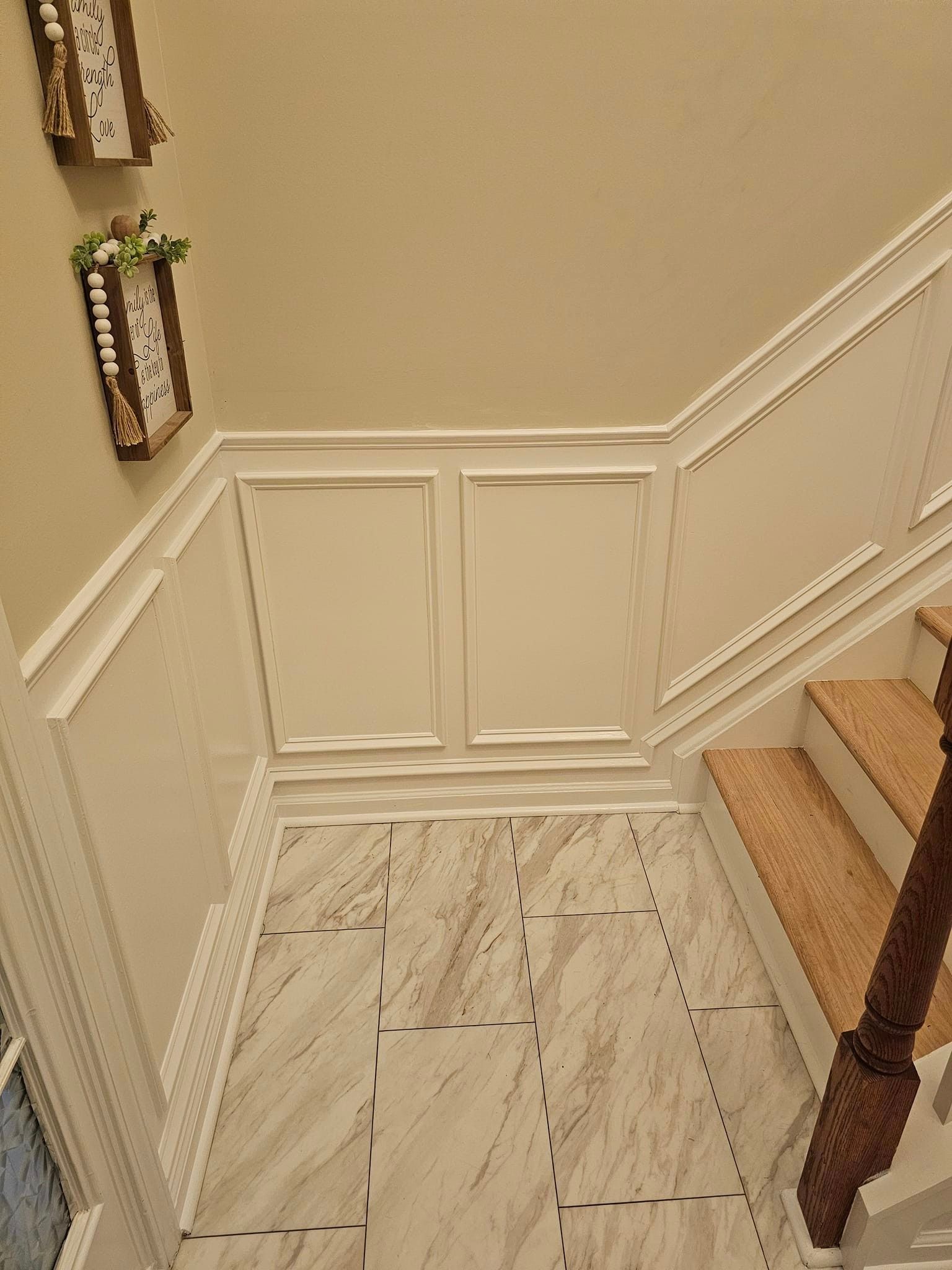 A staircase with a marble floor and a wooden railing.