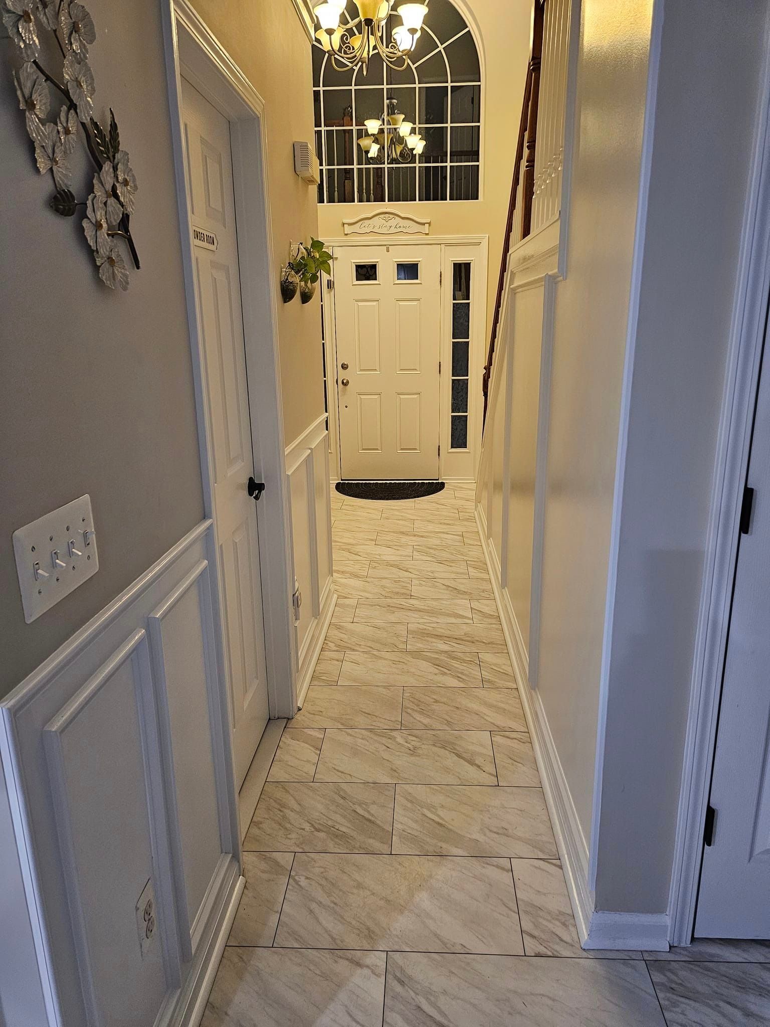 A long hallway leading to the front door of a house.
