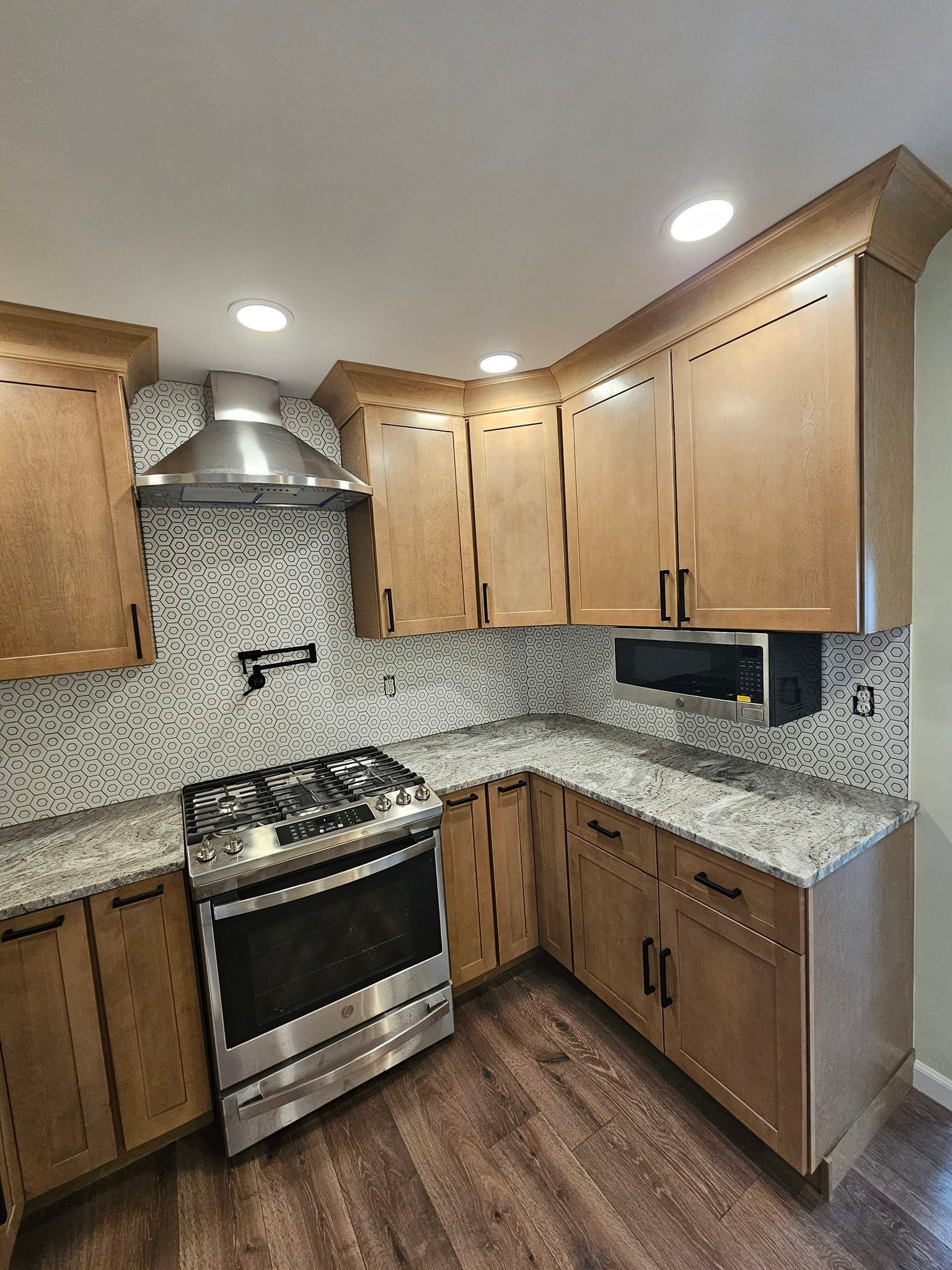 A kitchen with stainless steel appliances and wooden cabinets.