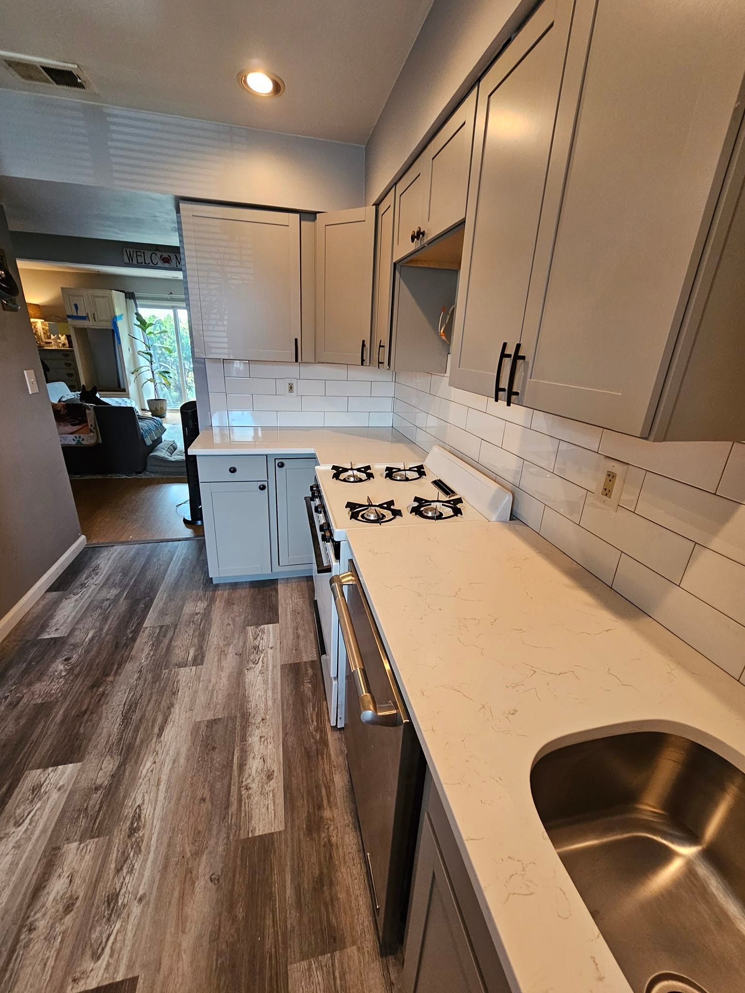 A kitchen with white cabinets, stainless steel appliances, and a sink.