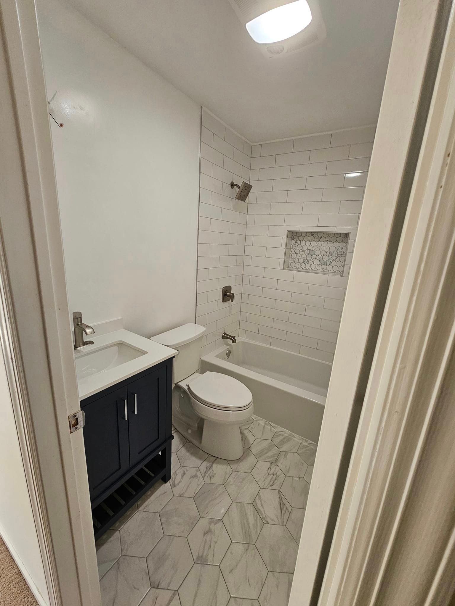 A bathroom with a toilet, sink, bathtub and shower.