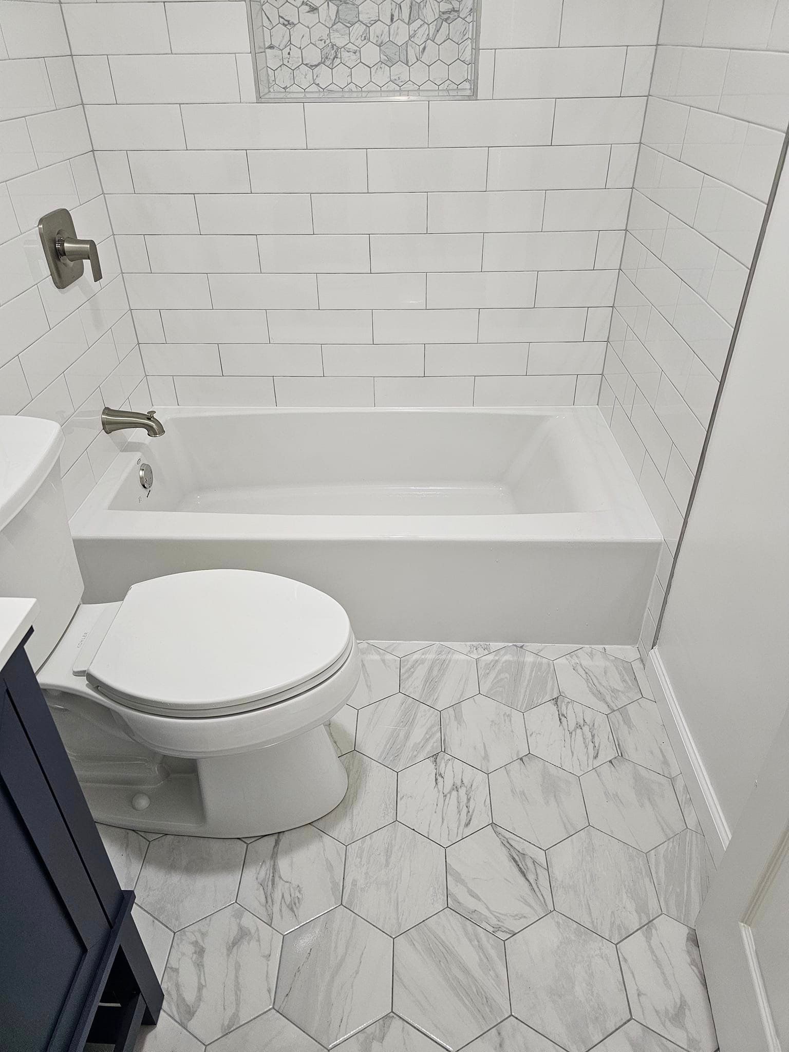 A bathroom with a toilet, sink and bathtub.