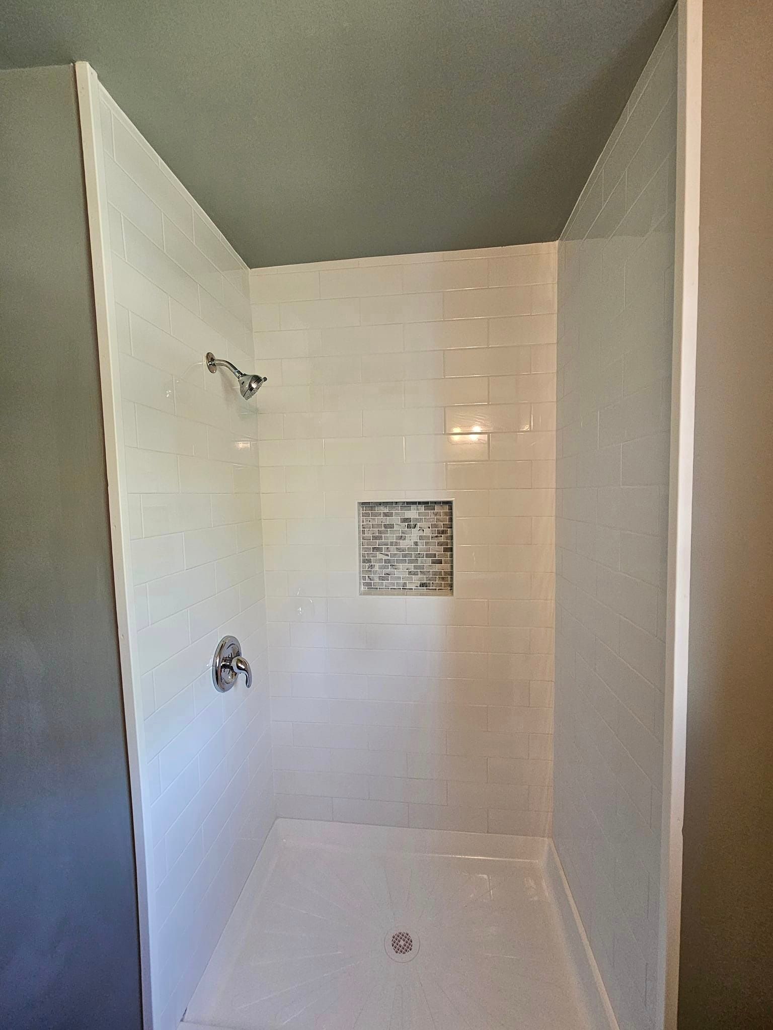 A bathroom with a walk in shower and a gray ceiling.