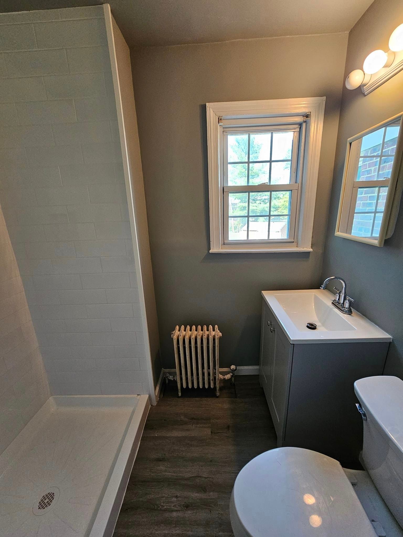 A bathroom with a toilet, sink, and shower.
