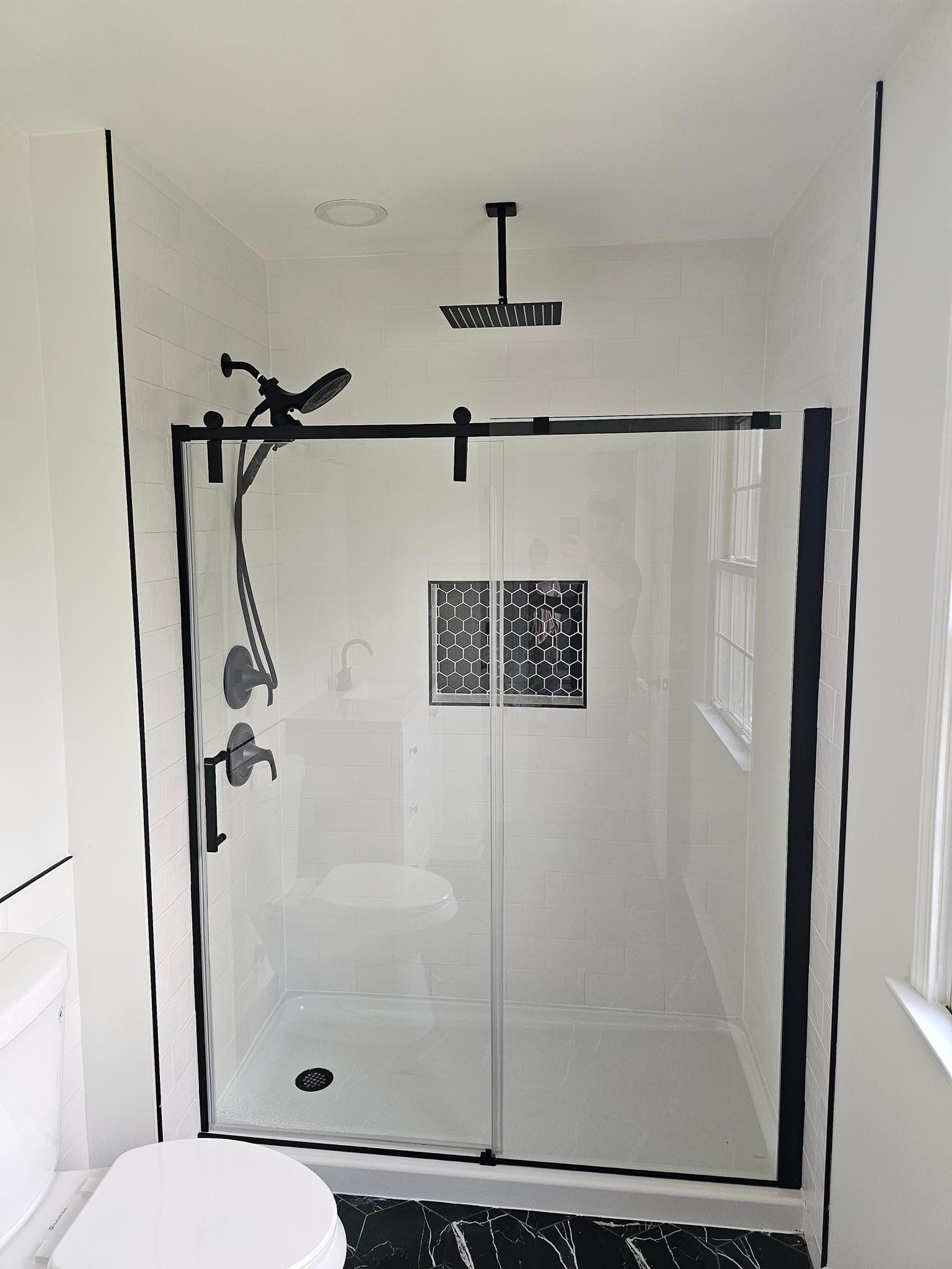 A bathroom with a sliding glass shower door and a toilet.