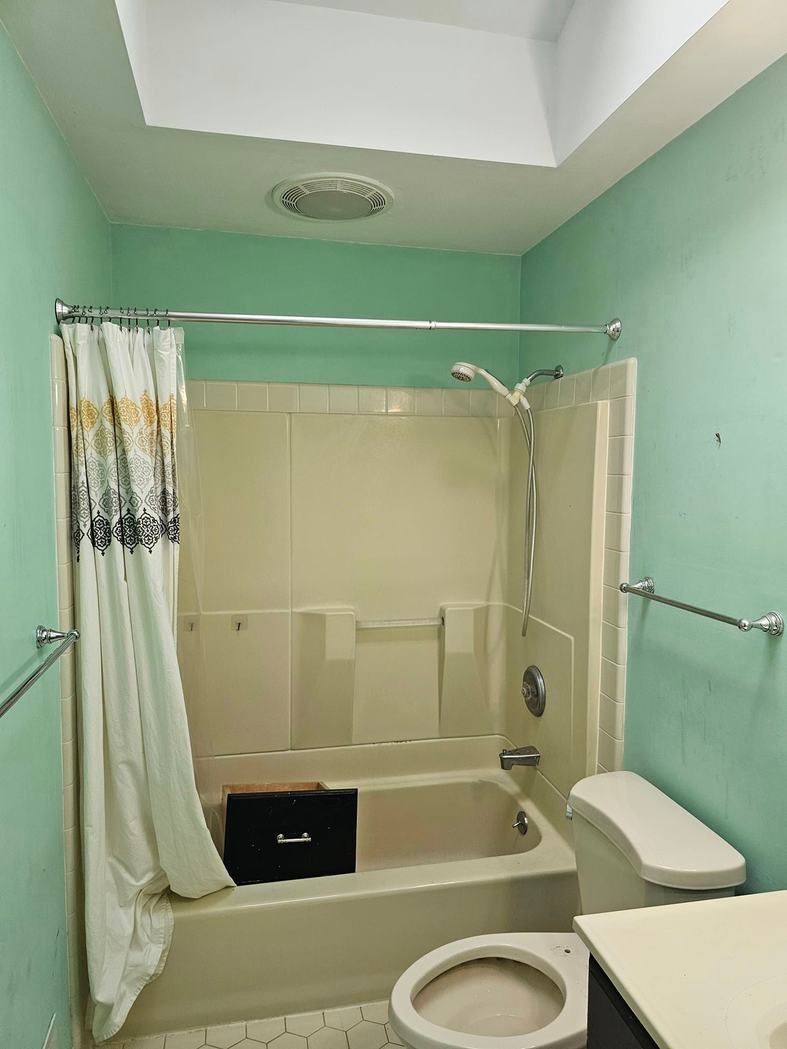 A bathroom with a tub, toilet, and shower.