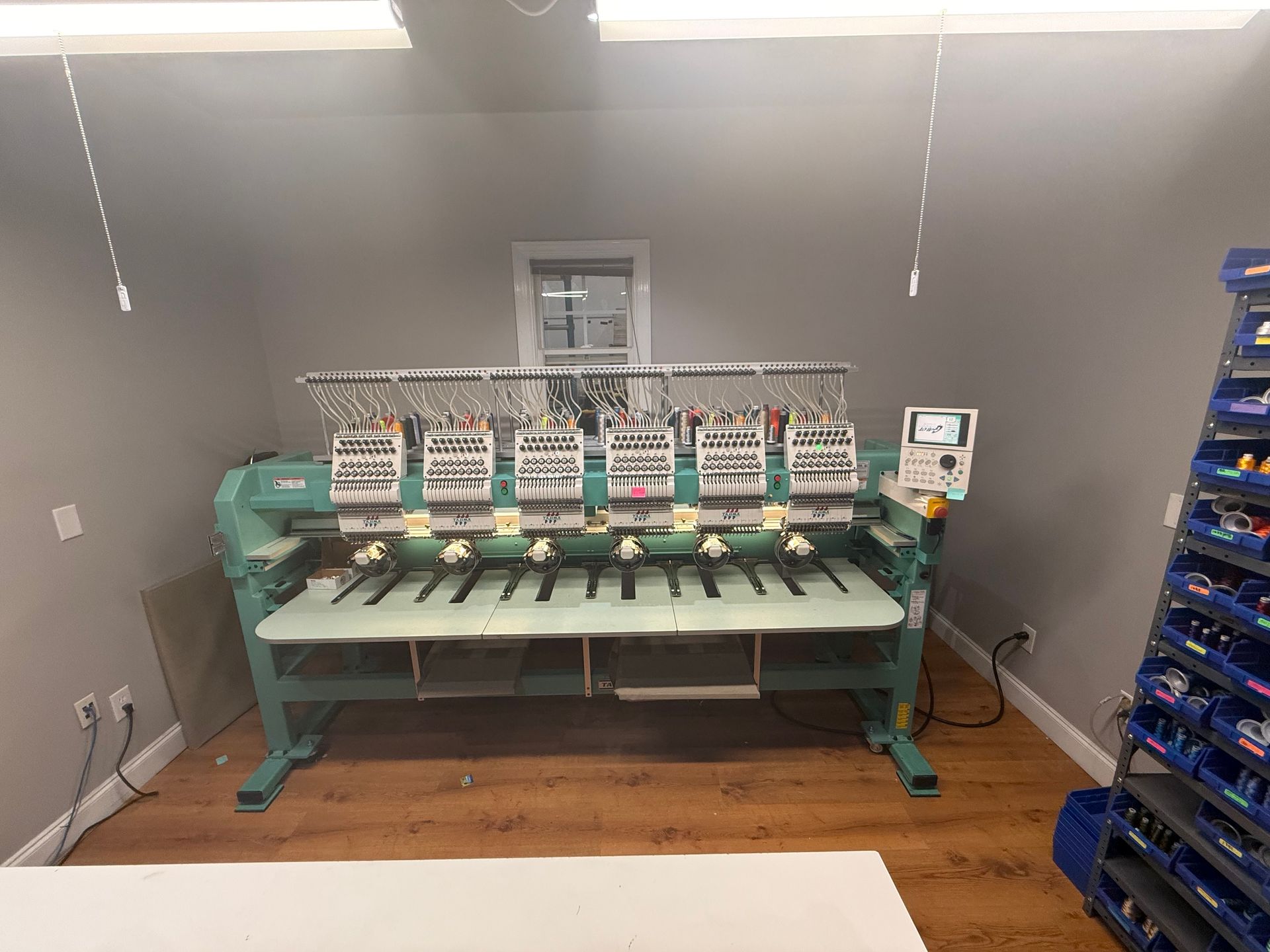 A machine is sitting in a room next to a shelf.