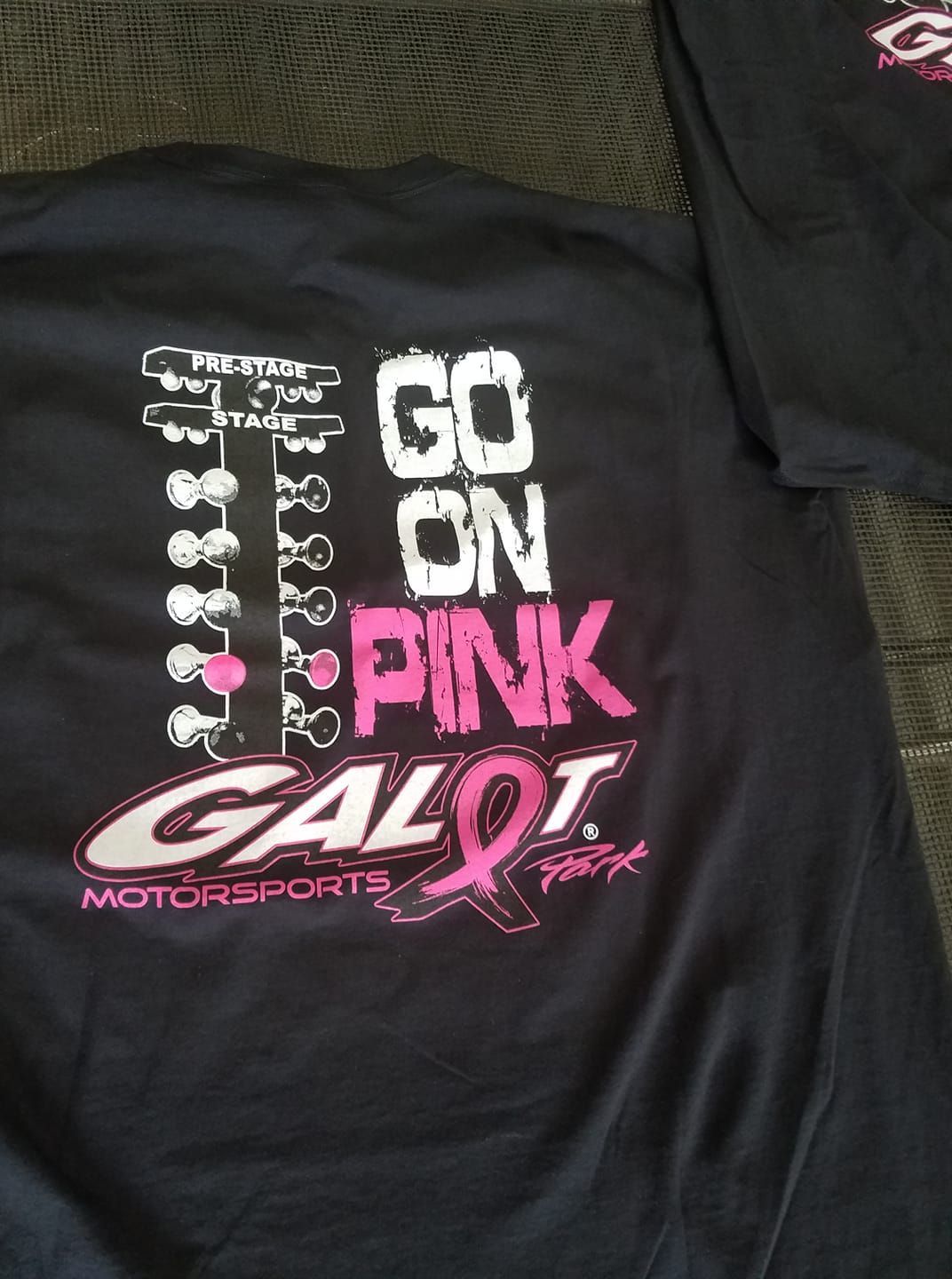 A black shirt that says go on pink on it