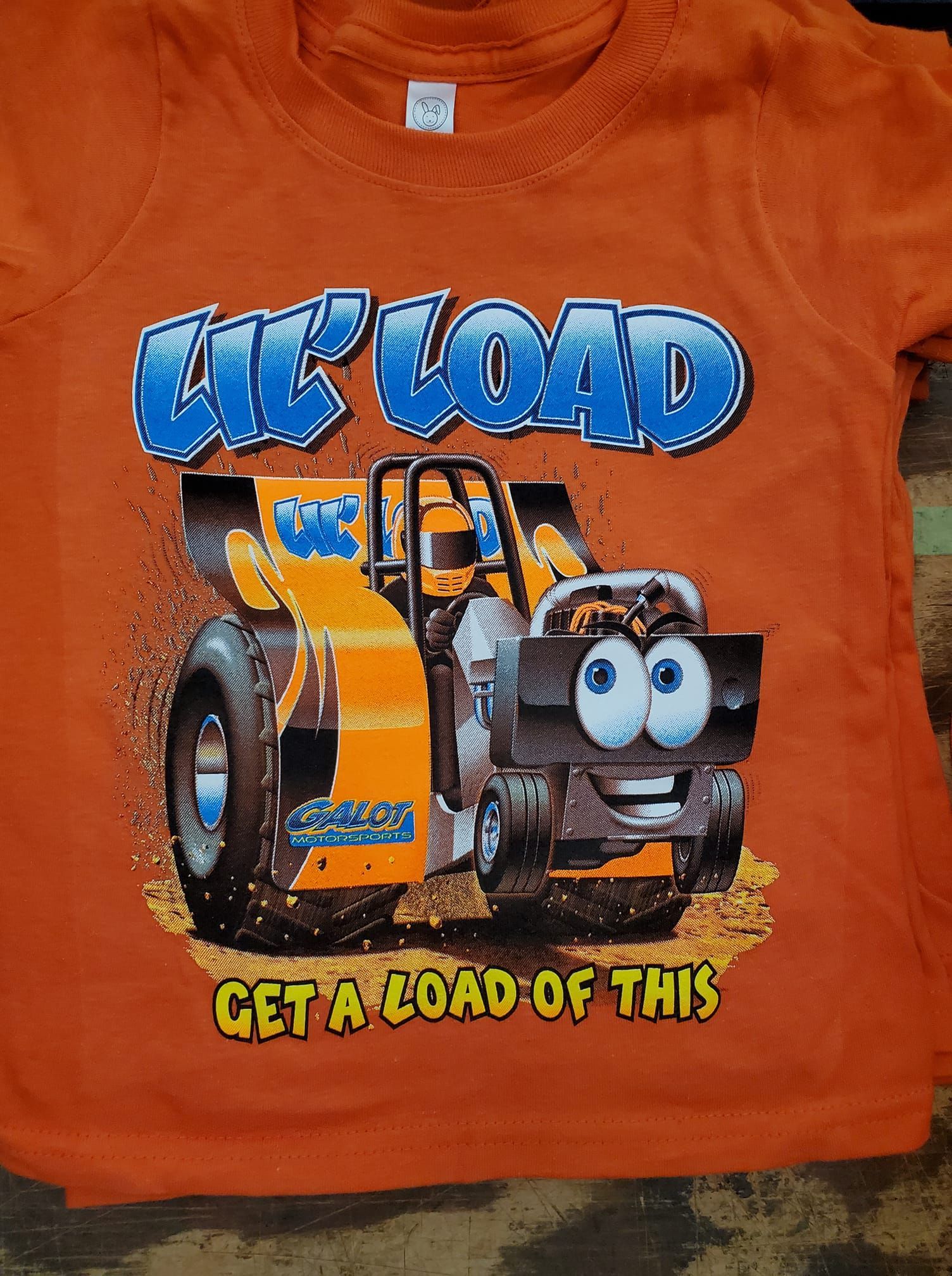 An orange t-shirt with a cartoon truck