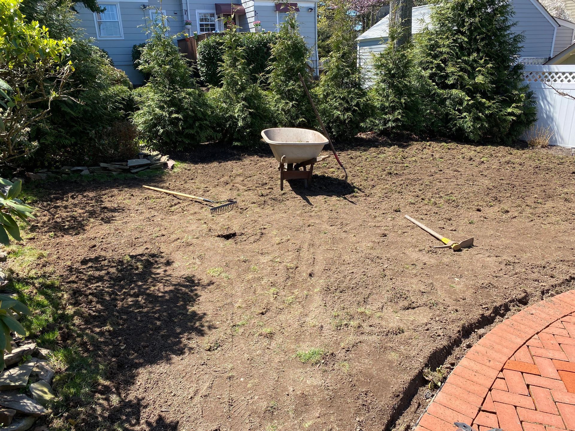 A wheelbarrow is sitting in the middle of a dirt field.