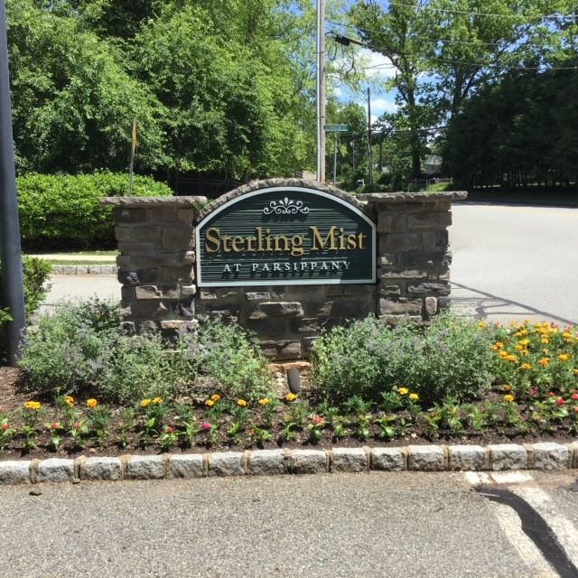 A sign for sterling mist is surrounded by flowers