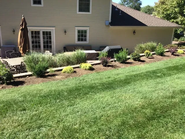 A house with a lush green lawn in front of it.