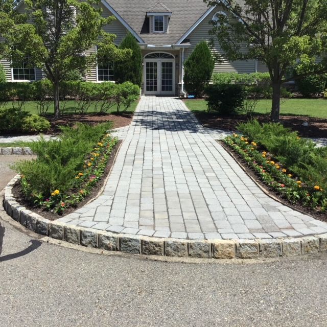 A brick walkway leads to a large house
