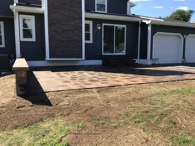 A blue house with a driveway in front of it.
