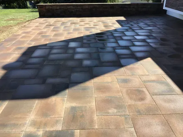 A brick patio with a shadow cast on it