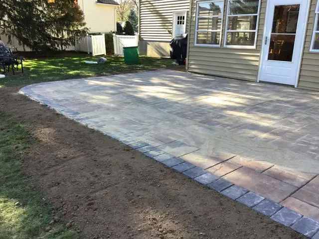 A patio is being built in the backyard of a house.
