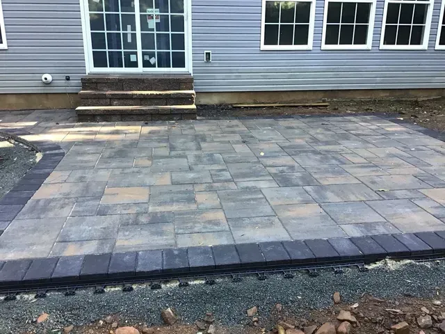 A patio is being built in front of a house.