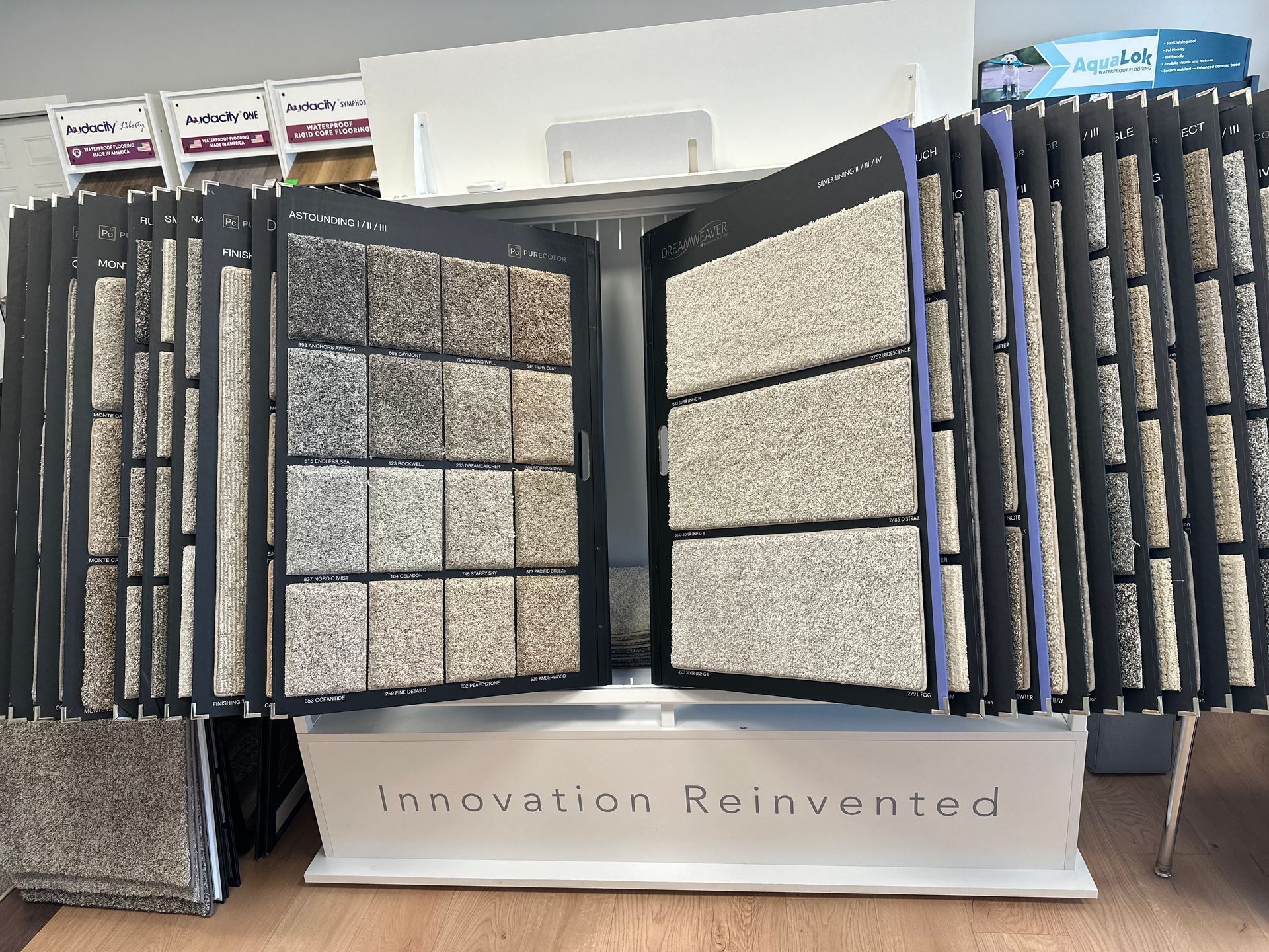 A display of carpets with a sign that says innovation reinvented