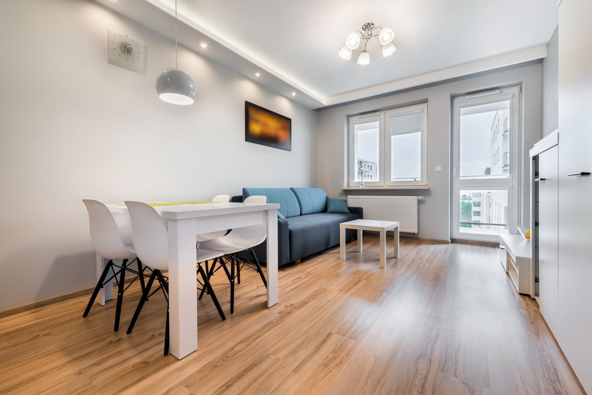 A living room with a couch , table and chairs.