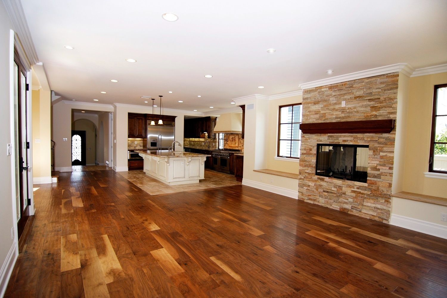 An empty living room with hardwood floors and a fireplace.